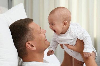 Mutlu baba evde bebeğini kucağında tutuyor.