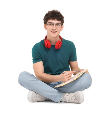 Not defteri ve kulaklığı olan beyaz arka planda oturan öğrencinin portresi