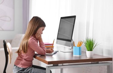 E-öğrenme. İçerideki masada ders sırasında not alan kız.