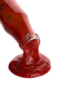 Beyaza izole edilmiş şişeden lezzetli ketçap dökülüyor. Domates sosu.
