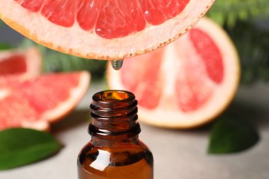 Masada meyve suyundan şişeye greyfurt suyu damlatıyor, yakın plan. Metin için boşluk