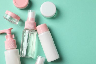 Turkuaz arka planda kozmetik seyahat seti, düz yatış. Metin için boşluk