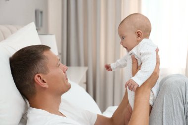 Mutlu baba evde bebeğini kucağında tutuyor.