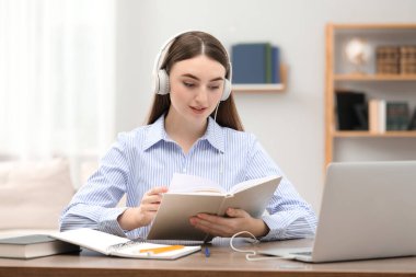 E-öğrenme. İnternetteki ders sırasında kitabı olan genç bir kadın.
