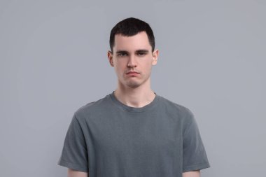 Gri arka planda üzgün bir adamın portresi