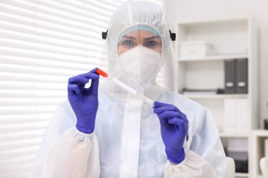 Laboratuvar testi. Üniformalı bir doktor hastanede pamuklu çubuk ve tüp kullanıyor.