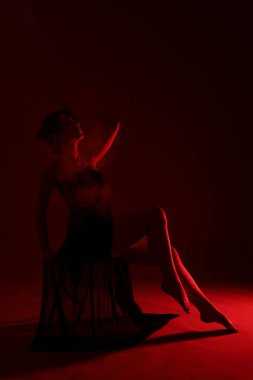 Koyu kırmızı arka planda dumanı olan çekici bir kadın portresi.