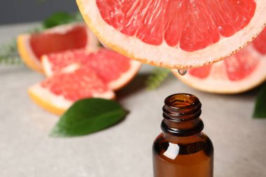 Masada meyve suyundan şişeye greyfurt suyu damlatıyor, yakın plan. Metin için boşluk