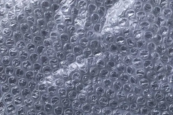 Transparent bubble wrap on black background, top view