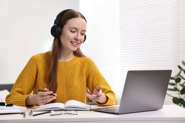 Stock image E-learning. Young woman using laptop during online lesson at white table indoors