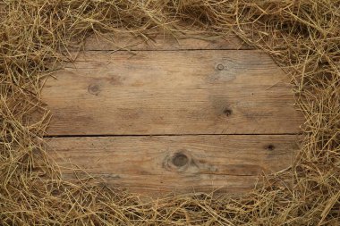 Frame made of dried hay on wooden background, top view. Space for text clipart
