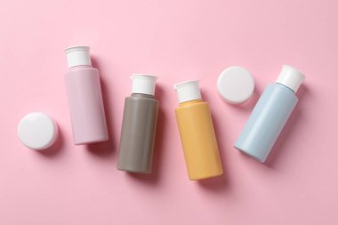 Pembe arka planda kozmetik seyahat seti, düz yatış. Banyo aksesuarları