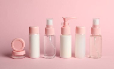 Pembe arka planda kozmetik seyahat. Banyo aksesuarları