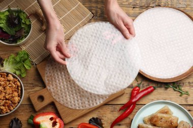 Ahşap masada nefis börek yapan bir kadın.