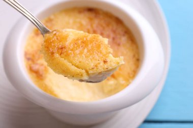 Açık mavi masada kaseden kaşıkla leziz bir creme brulee alıp yakın plan çekiyoruz.