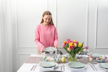 Bayramlık Paskalya yemeği için masa hazırlayan kadın.
