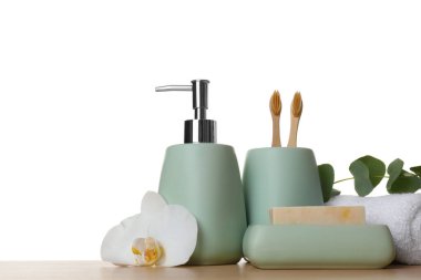 Banyo aksesuarları. Farklı kişisel bakım ürünleri, çiçek ve okaliptüs dalları beyaz arka plana karşı ahşap masa üzerinde. Metin için boşluk