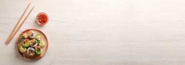 Sebze, sos ve yemek çubuklarıyla nefis börekler, ahşap masa, düz yatak. Metin için alanı olan pankart tasarımı