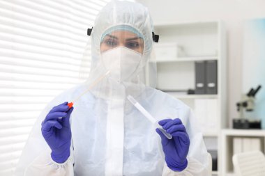 Laboratuvar testi. Üniformalı bir doktor hastanede pamuklu çubuk ve tüp kullanıyor.