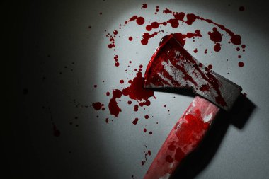Gri yüzey üzerinde kan olan balta. Karanlıkta, üst manzara. Metin için boşluk