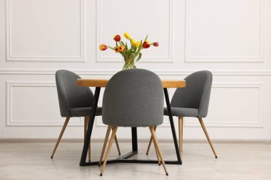 Rahat mobilyalar ve güzel lalelerle dolu şık bir yemek odası.