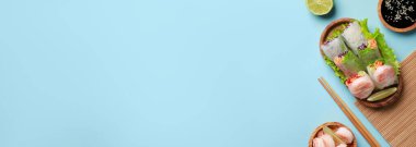 Lezzetli börekler, karidesler, limon, soya sosu ve açık mavi arka planda çubuklar. Metin için alanı olan pankart tasarımı