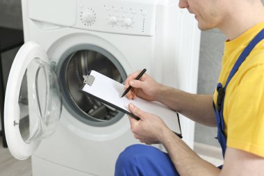 Banyodaki çamaşır makinesinin inceleme sonuçları, yakın çekim.