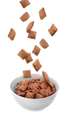 Mısır çerezi. Tahıl gevreği pedleri beyaz arkaplana karşı kabın içine düşüyor