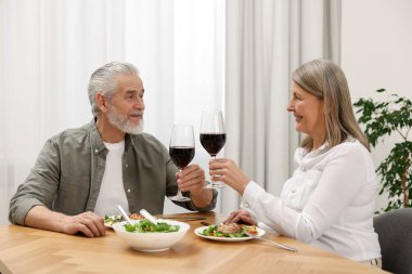 Mutlu son sınıf çifti evde romantik bir akşam yemeği yiyor.