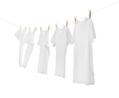 Çamaşır ipinde kuruyan birçok tişört beyaza izole edilmiş.