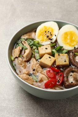 Gri masada bir kase lezzetli ramen. Erişte çorbası.