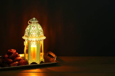 Dekoratif Arap feneri ve masada koyu arkaplan üzerine tarihler. Metin için boşluk