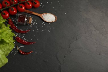 Yemek pişirme konsepti. Kaşık ve farklı ürünler siyah masada, düz yerde. Metin için boşluk