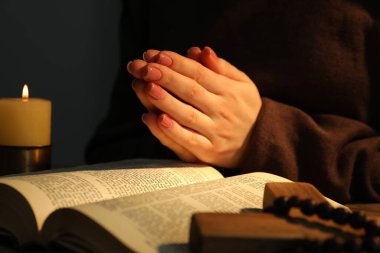 Masada yanan mum ve İncil 'le dua eden kadın, yaklaş.