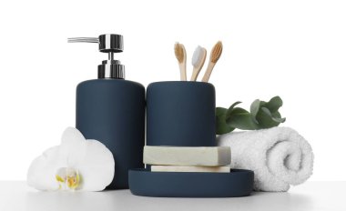 Banyo aksesuarları. Masadaki farklı kişisel bakım ürünleri, çiçek ve okaliptüs dalı beyaz arka plana karşıdır