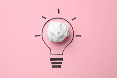 Fikir konsepti. Buruşmuş kağıttan yapılmış ampul ve pembe arkaplanda çizim, üst görünüm