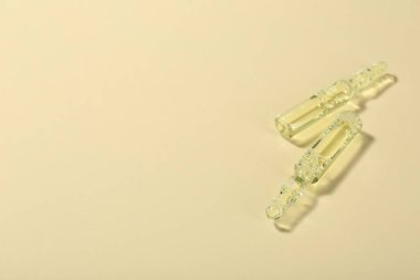 Bej arka planda sıvı olan cam ampuller. Metin için boşluk