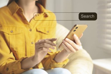 İnternet sitesini akıllı telefondan ara. Cihazı içeride kullanan kadın, yakın plan.