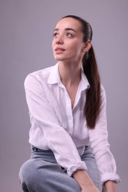 Açık gri arka planda güzel bir genç kadının portresi