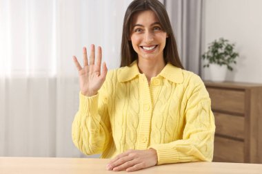 Mutlu kadın el sallıyor İçerideki masaya merhaba diyor