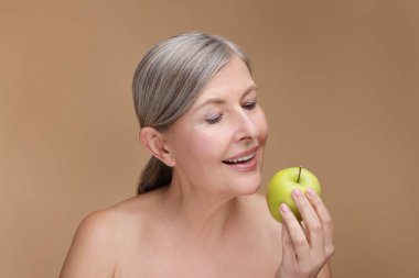 Bej arka planda taze elmalı güzel bir kadın. Vitamin zengini yiyecekler