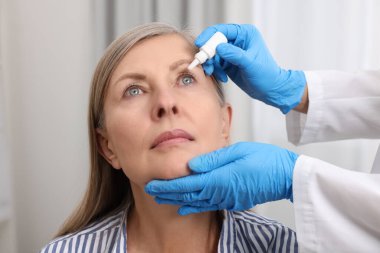 Tıbbi damlalar. Doktor içeride kadınların gözüne ilaç damlatıyor.