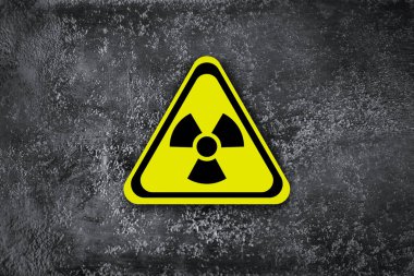 Gri duvarda radyoaktif tabela var. Tehlike sembolü