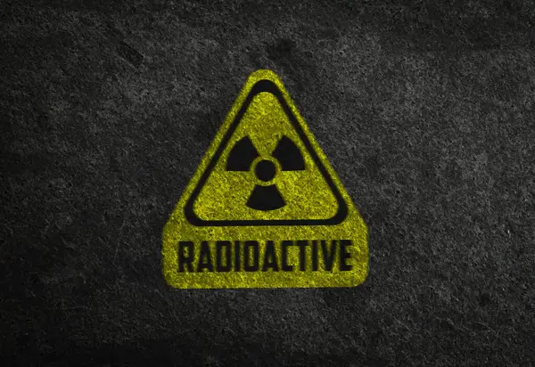 Radioactive sign on grey stone wall. Hazard symbol