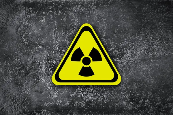 Radioactive sign on grey wall. Hazard symbol