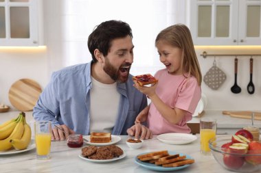 Babası ve küçük tatlı kızı mutfakta kahvaltı ederken eğleniyorlar.