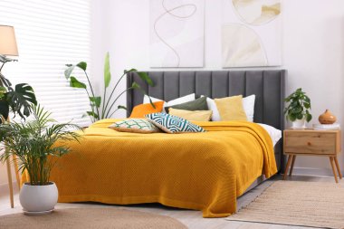 Parlak ekose ve renkli yastıklar şık bir yatak odasında. İç tasarım