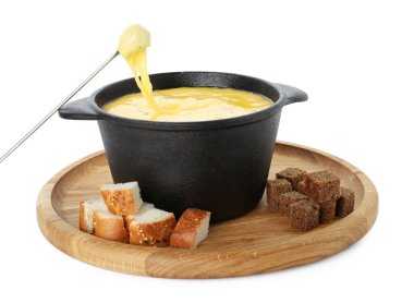 Beyaz üzerine izole edilmiş erimiş peynirle fondü kabına bir parça ekmek batırıyorum.