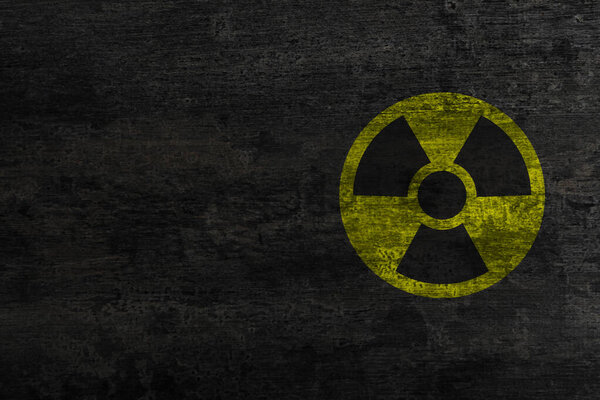 Radioactive sign on black stone wall, space for text. Hazard symbol