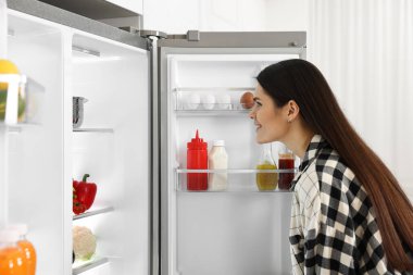 Genç kadının yanına modern mutfak buzdolabında